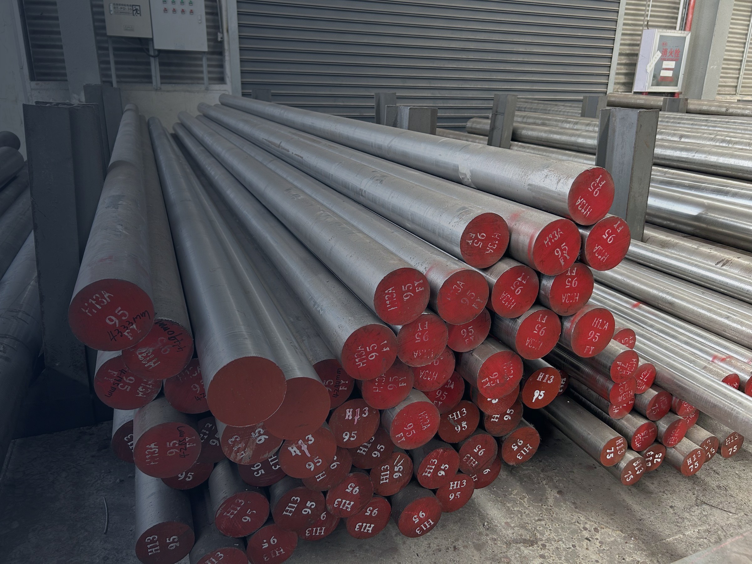 H13 tool steel round bars stacked in the Aobo Steel warehouse, bar ends marked with grade and diameter