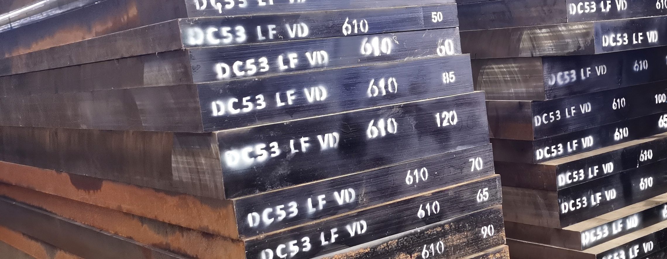 DC53 tool steel plates stacked at the mill, each plate marked DC53 LF VD at 610 mm width