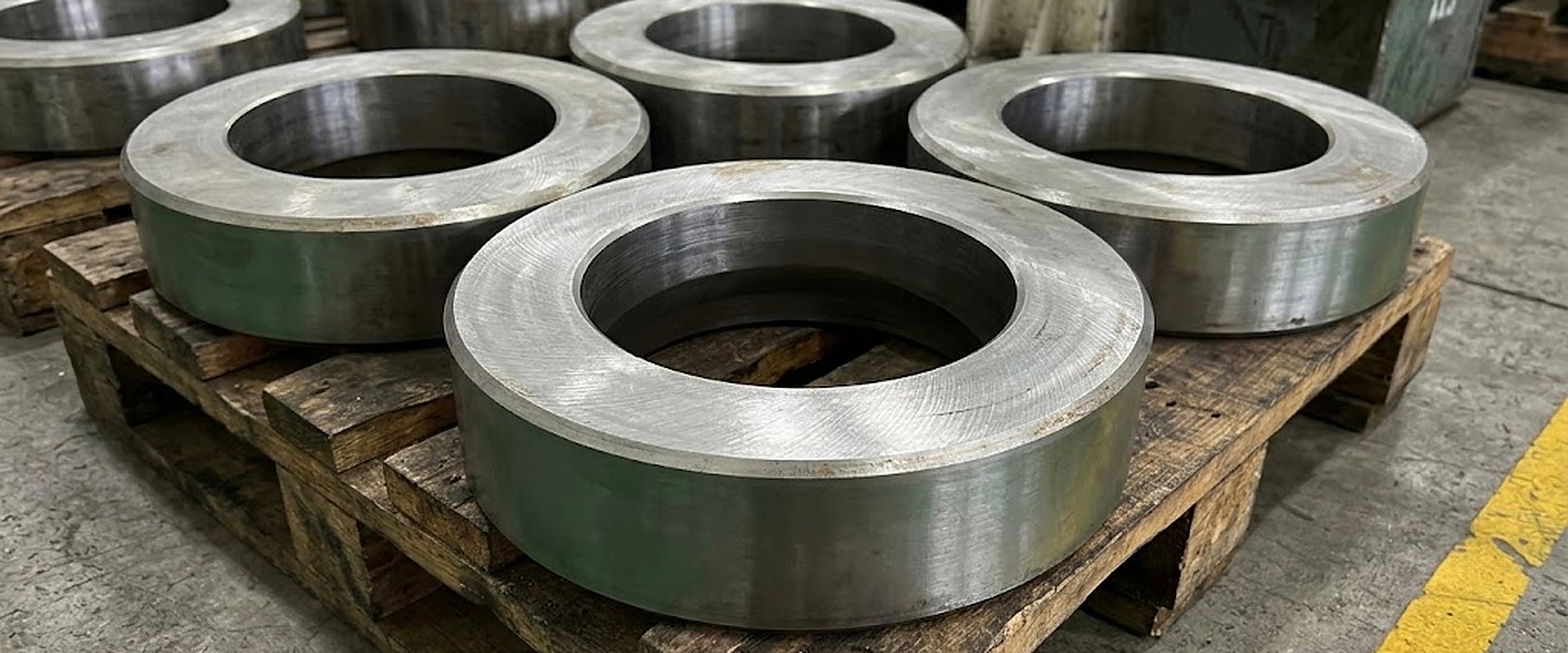 Rough machined H13 forged rings, bored and faced, stacked on timber pallets