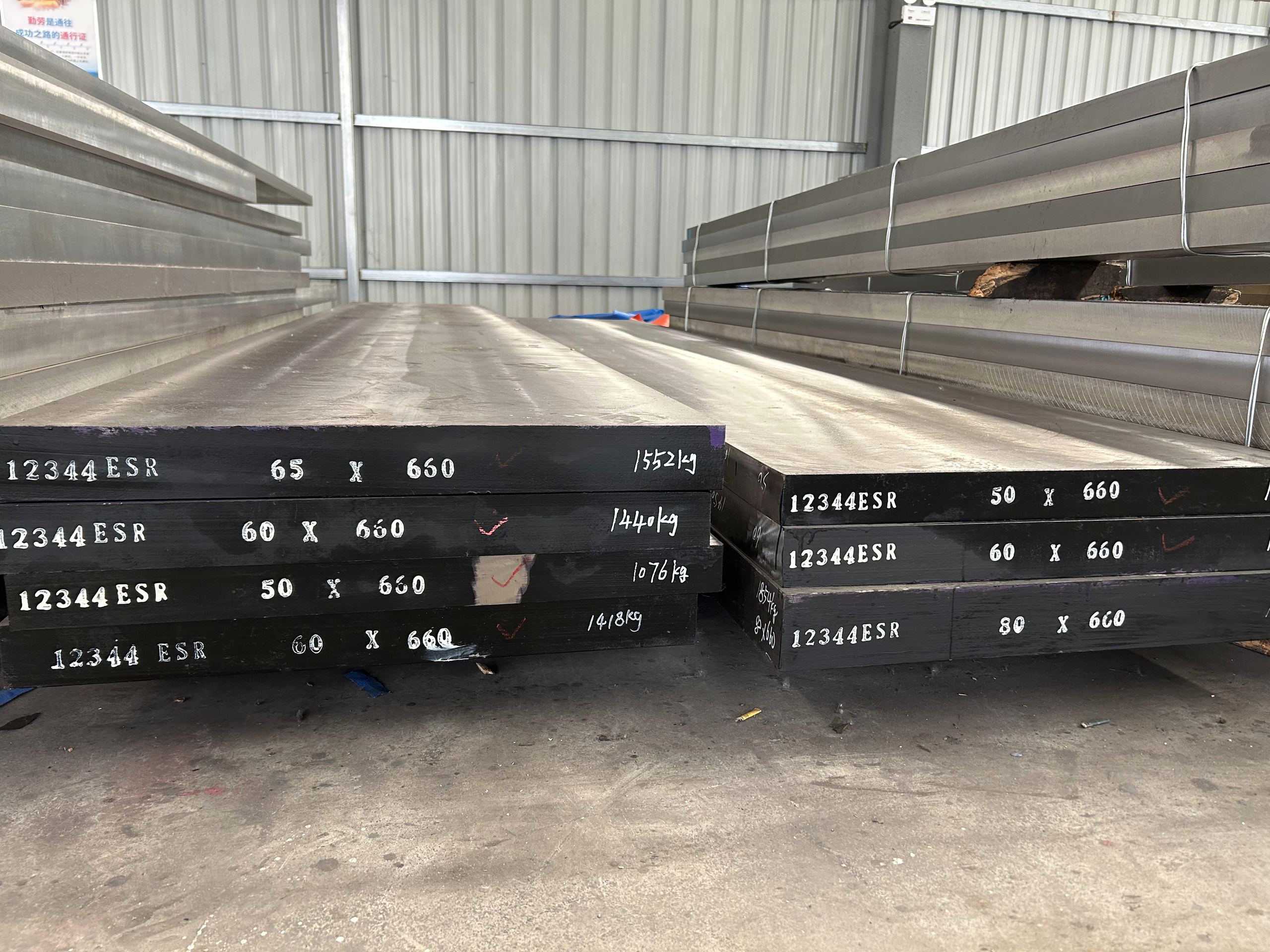 1.2344 ESR die steel plates stacked in a warehouse, plate ends painted 12344 ESR with the section size and weight